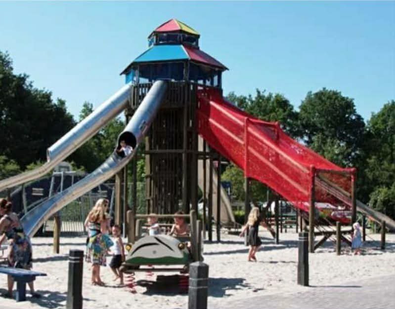 Hoge speeltoren met glijbanen in het zand